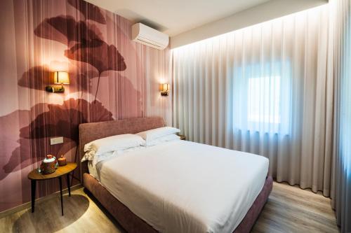 a hotel room with a bed and a window at Colle Serrano Relais & SPA in Ripatransone
