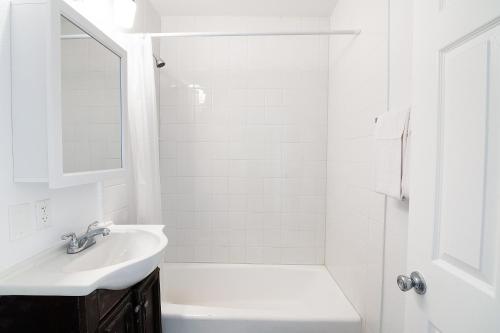 Un baño blanco con lavabo y ducha. en LA Royal Viking Apartments, en Los Ángeles