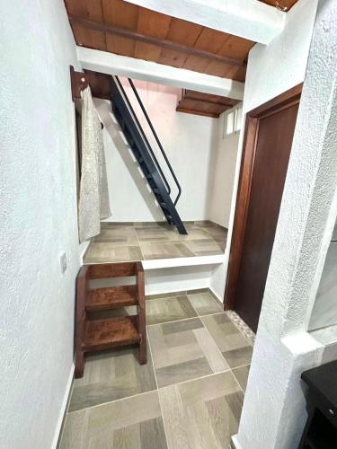 a hallway with a staircase with a wooden door at Departamento mini Huatulco in Santa Cruz Huatulco