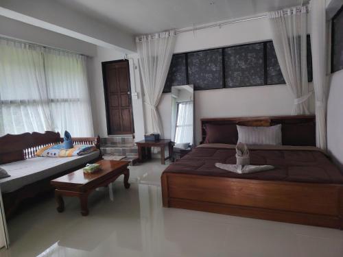a bedroom with a bed and a couch and a table at Sweet home pai in Pai