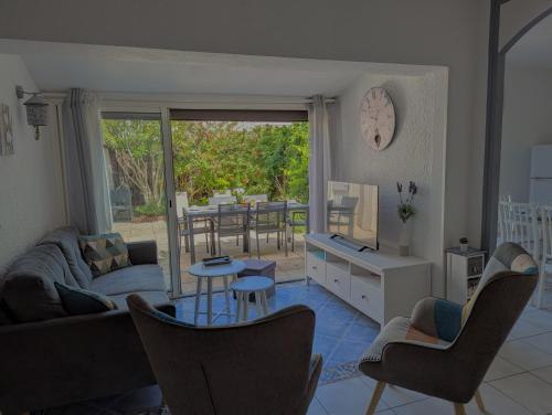 un salon avec un canapé, des chaises et une table dans l'établissement Sol-y-Days Grau Village, Superbe maison de vacances avec 3 chambres et un bel espace exterieur aménagé, au Grau-du-Roi