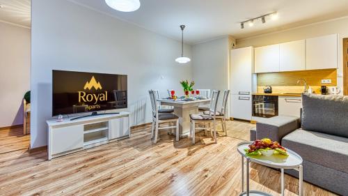a living room with a couch and a kitchen at Apartamenty z basenem i saunami STONE HILL RESORT II VIP Centrum by Royal Aparts in Szklarska Poręba