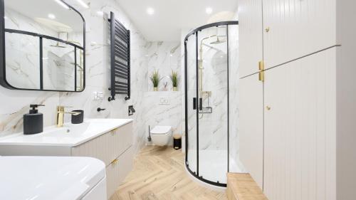 a white bathroom with a shower and a toilet at Promenada Komfort, Sun & Snow in Świnoujście