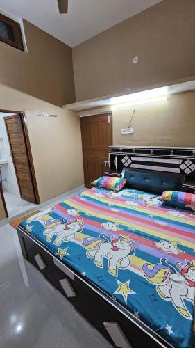 a bedroom with a large bed with a colorful blanket at Deva Guest House in Ayodhya
