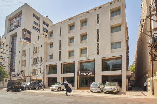 a man is walking in front of a building at Hotel The Evergrand Palace in Rajkot