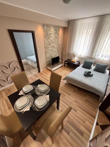 a living room with a table and chairs and a couch at Balian apartman in Siófok