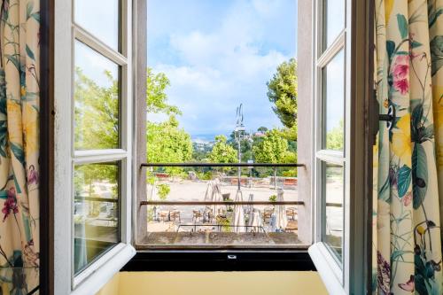 an open window with a view of a park at Grimaldi in Cagnes-sur-Mer