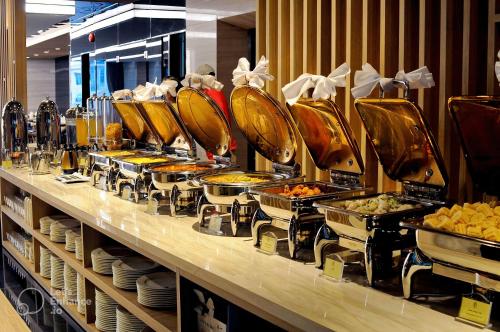 ニャチャンにあるBrilliant Bay Nha Trang Hotelのレストランで食べ物が並べられたビュッフェライン