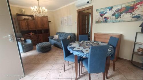 a dining room with a table and blue chairs at Casa Caterina in Cisano Bergamasco