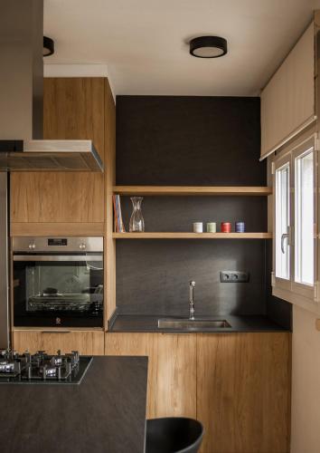 a kitchen with wooden cabinets and a sink at Mirador del Llac in Cellers