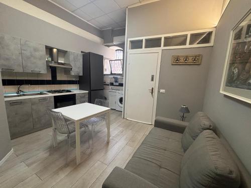 a living room with a couch and a table and a kitchen at Casa Rita-Superior Room in Giarre