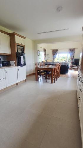 a kitchen and dining room with a table and chairs at High Meadow House in Duncormick