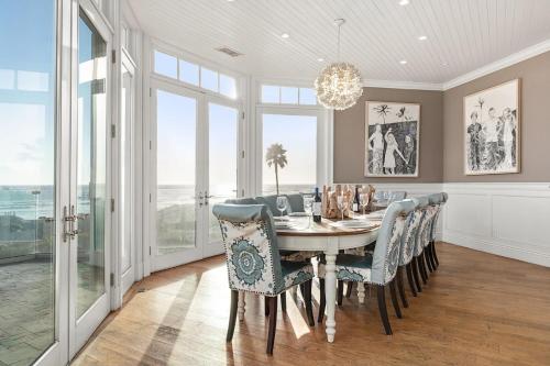 a dining room with a table and chairs and windows at Malibu Dunes by Fieldtrip Expansive Hamptons-Style Estate w Private Beach Backyard in Malibu