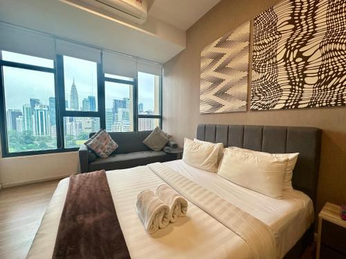 une chambre avec un grand lit et un canapé dans l'établissement Ceylonz Suites KLCC By KL Tower, à Kuala Lumpur