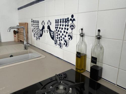 - une cuisine avec 2 bouteilles de vin sur le comptoir dans l'établissement La Mouette - Superbe romantique cœur de ville, à Trouville-sur-Mer