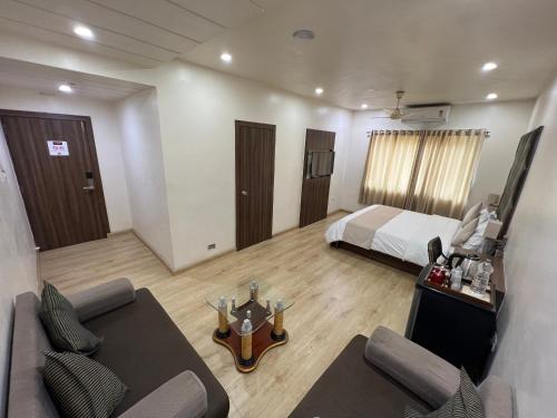 a hotel room with a bed and a living room at Hotel The Evergrand Palace in Rajkot