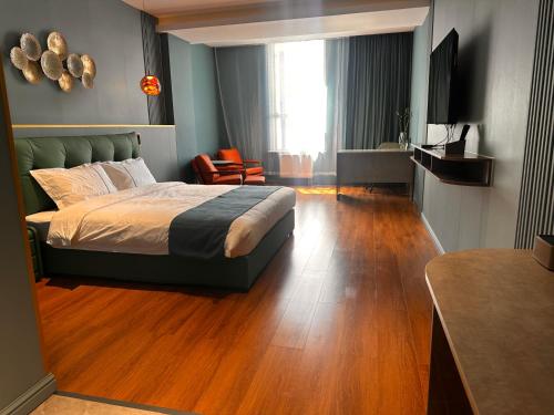 a bedroom with a bed and a wooden floor at Bojon Hotel Ulaanbaatar - Soyolj Mall in Ulaanbaatar