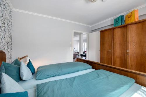 a bedroom with two beds and wooden cabinets at Ferienwohnung Alte Tischlerei in Hemmingstedt