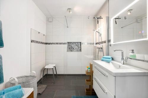 a white bathroom with a sink and a shower at Ferienwohnung Alte Tischlerei in Hemmingstedt
