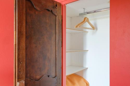 a closet with a wooden door and a red wall at Grimaldi in Cagnes-sur-Mer
