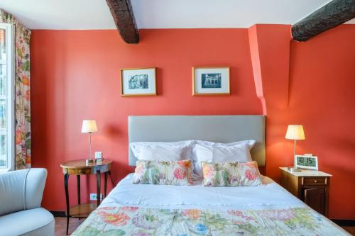 a bedroom with red walls and a bed with pillows at Grimaldi in Cagnes-sur-Mer
