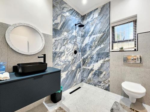 a bathroom with a sink and a mirror at Blue Emerald Villa in Cape Town