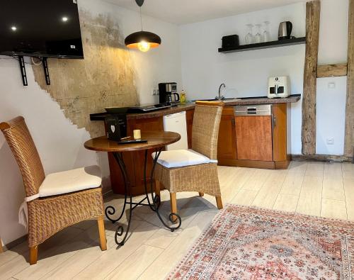 a kitchen with a table and chairs and a counter at Wiesenau Apartments by Restaurant WIESENAU in Prerow