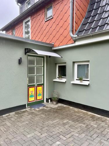 a cat sitting in front of a house at Wiesenau Apartments by Restaurant WIESENAU in Prerow