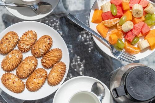 een tafel met twee borden eten en een fruitschaal bij The Chail Resort, Chail in Chail