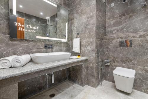 a bathroom with a sink and a toilet and a mirror at The Chail Resort, Chail in Chail