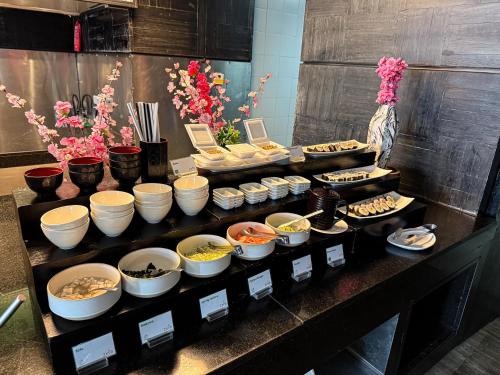 a buffet line with bowls and plates of food at Holiday Inn Bangkok Sukhumvit by IHG in Bangkok
