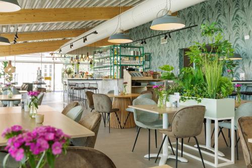 a restaurant with tables and chairs and flowers at Duinresort Dunimar in Noordwijkerhout