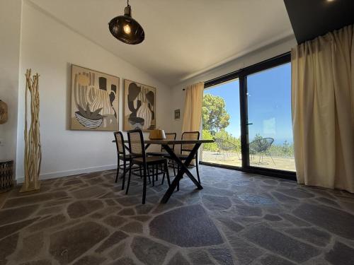 a dining room with a table and chairs and a large window at V.V. Verde Amanecer 2 in Las Casas