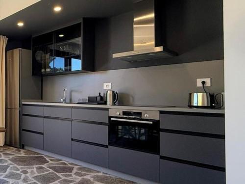 a kitchen with black and gray cabinets and appliances at V.V. Verde Amanecer 5 in Las Casas