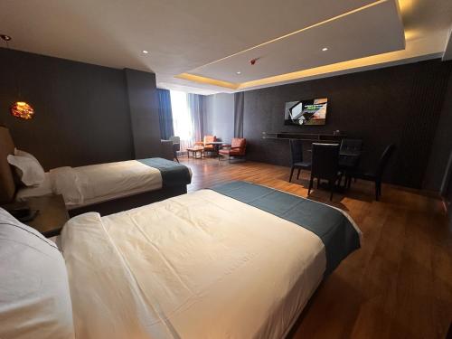 a hotel room with two beds and a living room at Bojon Hotel Ulaanbaatar - Soyolj Mall in Ulaanbaatar