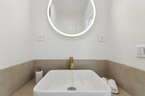 une salle de bain avec un lavabo blanc et un miroir dans l'établissement Apartment in Paris 2ème, à Paris