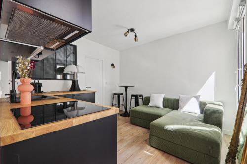 Il comprend une cuisine et un salon avec un canapé vert. dans l'établissement Apartment in Paris 2ème, à Paris
