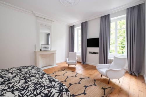 - une chambre avec un lit, deux chaises et une télévision dans l'établissement Bâtisse historique rénovée avec piscine chauffée, à Saint-Martin-de-Ré