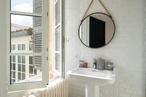 une salle de bain blanche avec un miroir et un lavabo dans l'établissement Bâtisse historique rénovée avec piscine chauffée, à Saint-Martin-de-Ré