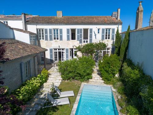 une vue extérieure d'une maison avec piscine dans l'établissement Bâtisse historique rénovée avec piscine chauffée, à Saint-Martin-de-Ré