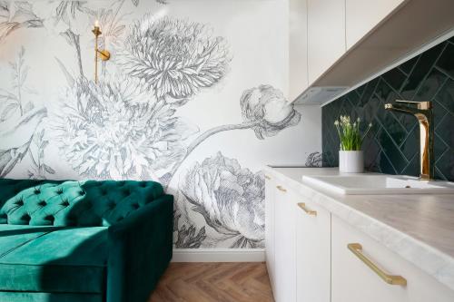 Un baño con una silla verde delante de un lavabo. en Elite Apartments Ogarna Suites Old Town, en Gdansk