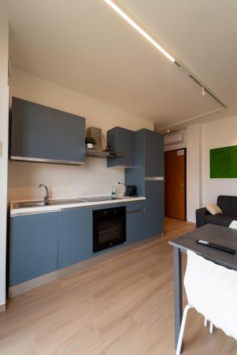a kitchen with blue cabinets and a table at Appartamento incantevole a due passi dal mare 3 in Alba Adriatica