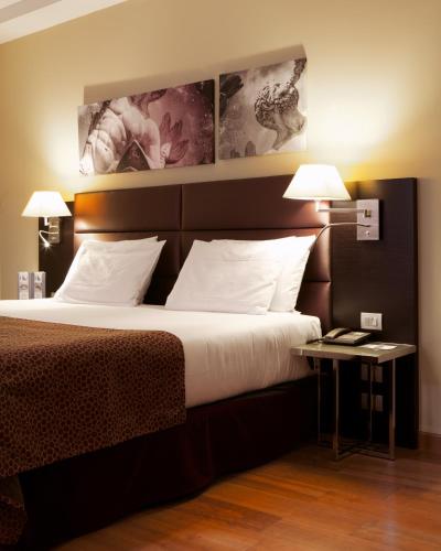 a bedroom with a large bed and two lamps at Eurostars Roma Aeterna in Rome