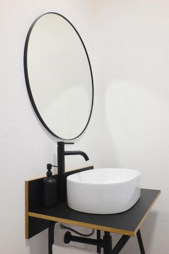 a bathroom with a sink and a mirror on a table at The Black Sheep BnB in Arbus