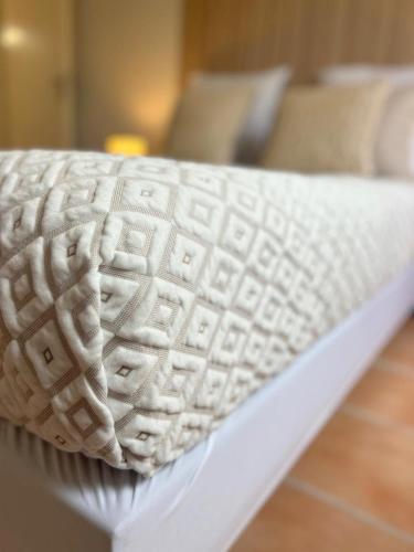 - une fermeture d'un matelas blanc sur un lit dans l'établissement Les Nuits d'Embalens, à Castelnau-dʼEstrétefonds