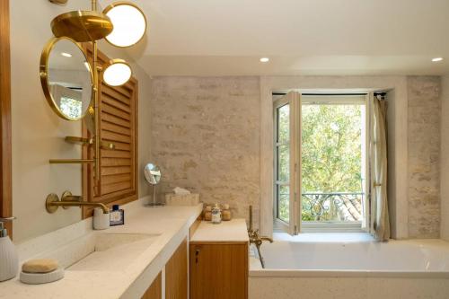 a bathroom with a tub and a sink and a window at GRANDE BELLEZZA in Ars-en-Ré