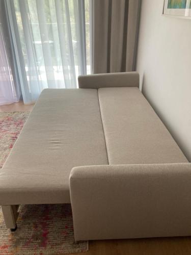 a bed sitting in a room next to a window at Pinia Slnava 01 - Luxury lakeside apartment with pool in Banka