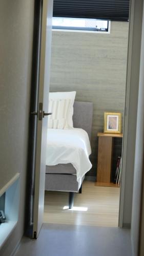 a bedroom with a white bed and a window at Jasmin T18 高松港近く 静かで美しい別荘 in Takamatsu