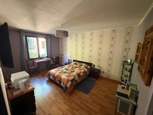 une chambre avec un lit, un bureau et une fenêtre dans l'établissement Maison au calme à la campagne, à Saint-Pierre-de-Bailleul