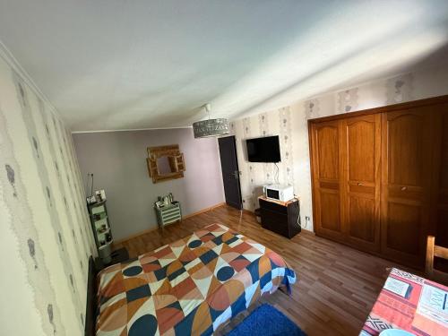 une chambre avec un lit et une télévision dans l'établissement Maison au calme à la campagne, à Saint-Pierre-de-Bailleul